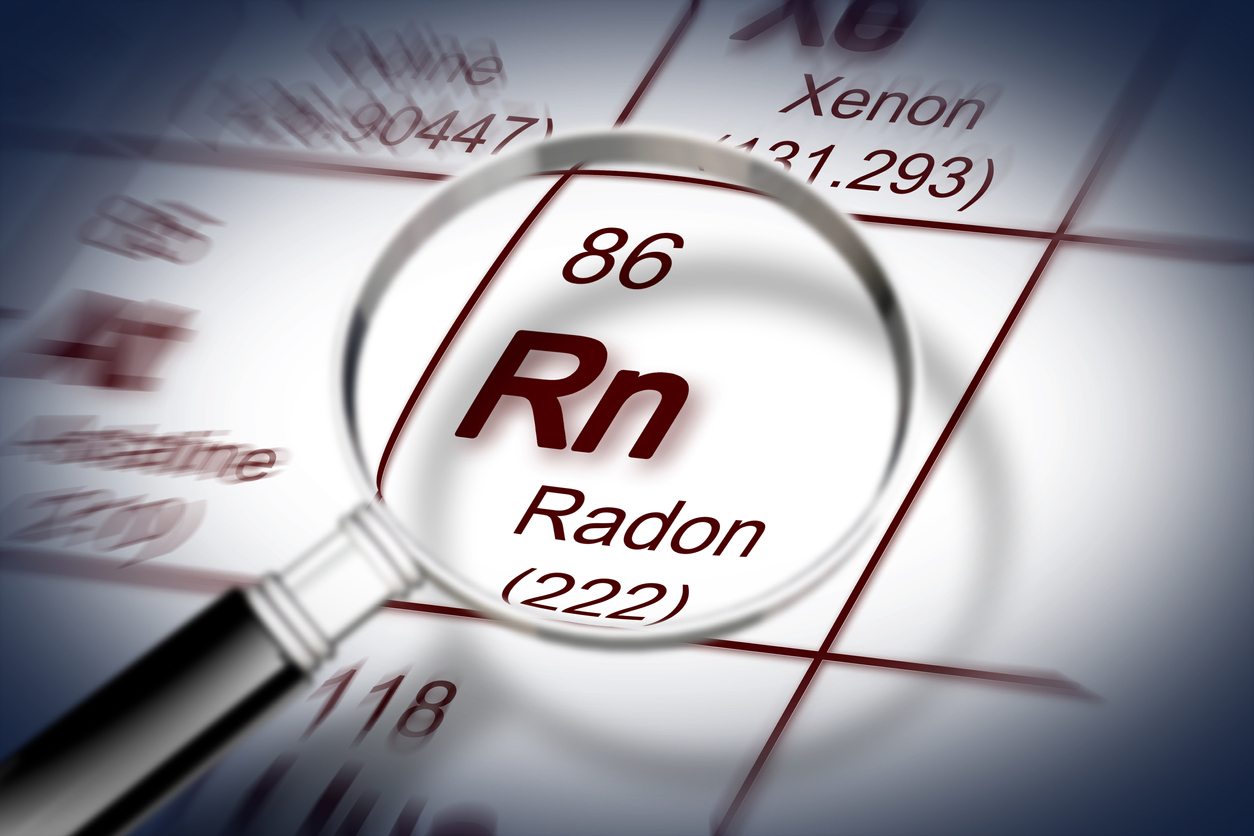 The danger of radon gas - concept image with periodic table of the elements and magnifying lens